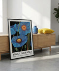 Framed Yayoi Kusama artwork in a modern room with wooden furniture and decor.