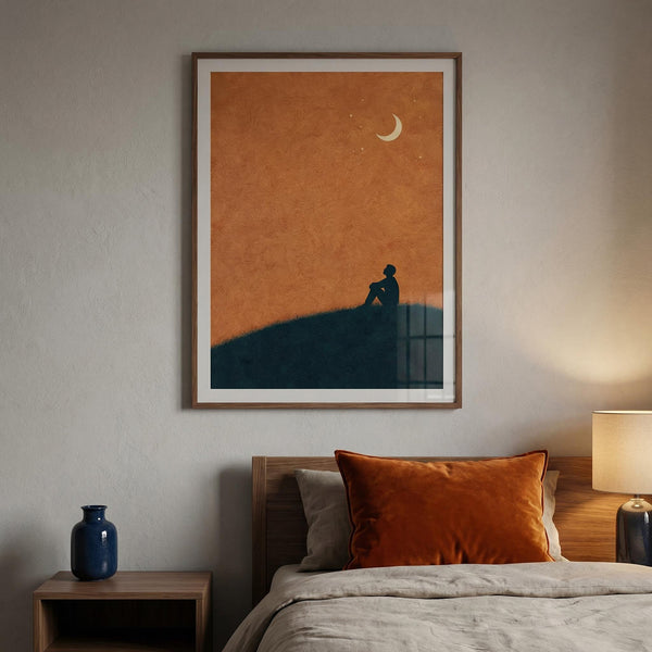 Framed artwork above a bed with orange accents