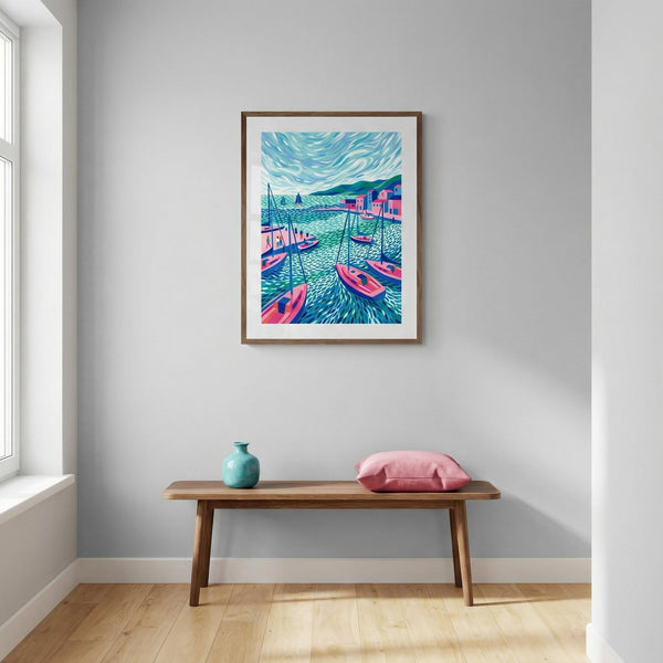 Framed artwork of a colorful coastal scene on a wall above a wooden bench with a vase and pillow.