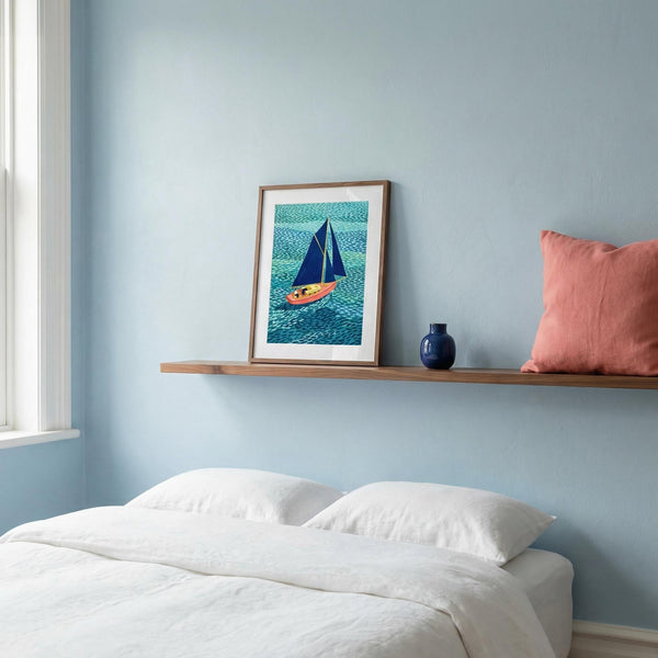 Framed artwork of a sailboat on a shelf above a bed with a pink pillow.