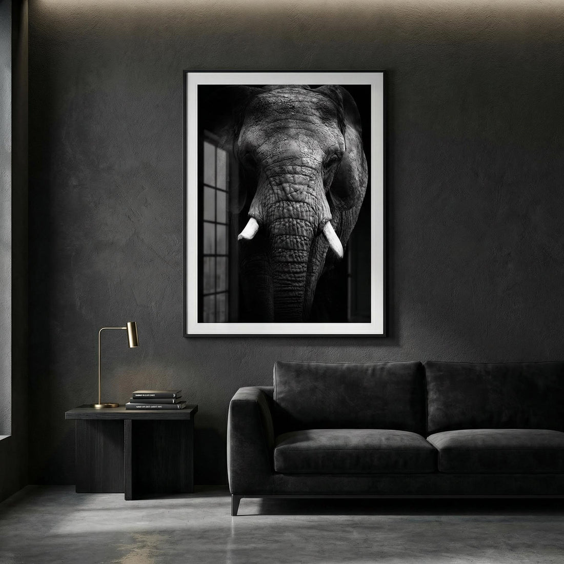 Black and white elephant photograph in a black frame above a dark velvet sofa in a moody grey living room