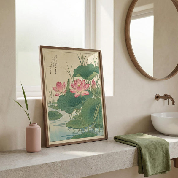 Framed artwork of pink lotus flowers in a bathroom setting with a mirror and sink.