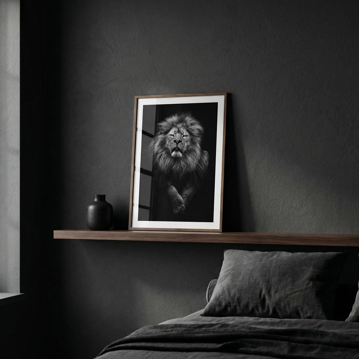 Framed black and white lion print on a dark wall above a wooden shelf.