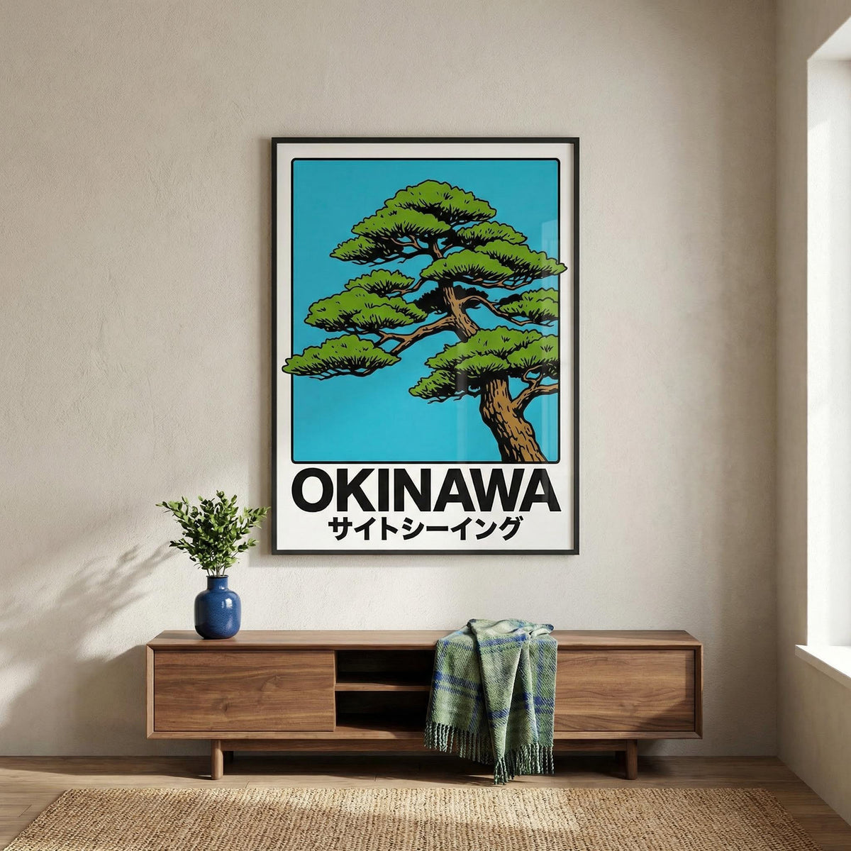 Framed poster of a tree with 'Okinawa' text on a wall above a wooden cabinet.