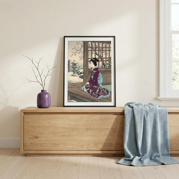 Framed artwork of a traditional Japanese scene on a wall above a wooden cabinet.