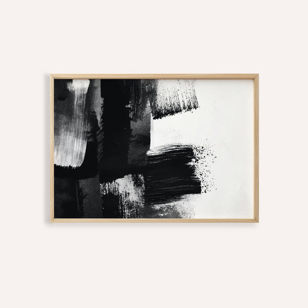 Abstract black and white art print in a wooden frame on a white wall