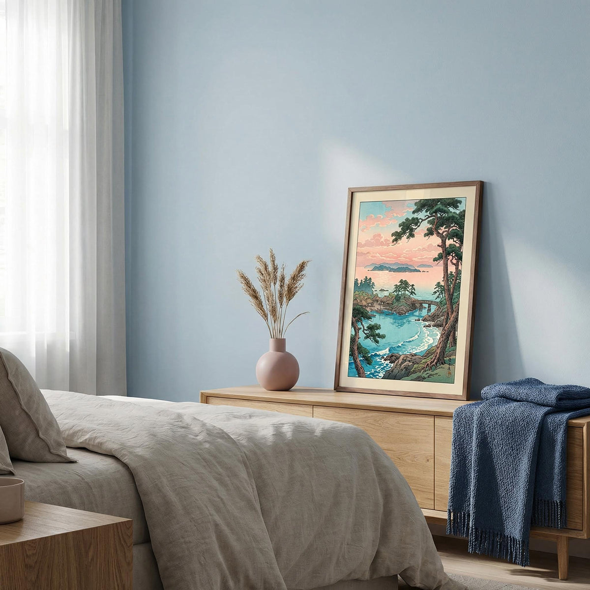 Framed artwork above a dresser in a bedroom with a scenic landscape.