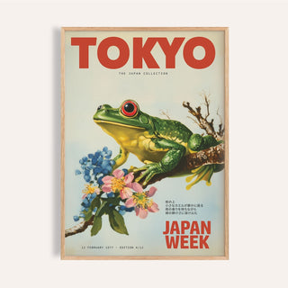 Frog wall art of a green frog on a branch with blue and pink flowers in a wooden frame