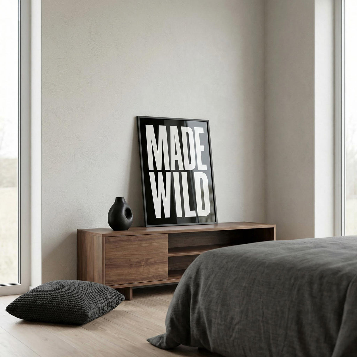 Modern bedroom with 'MADE WILD' framed artwork on a wooden console table.