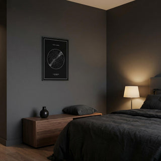 Modern bedroom with dark walls, a bed, nightstand, and framed map on the wall.