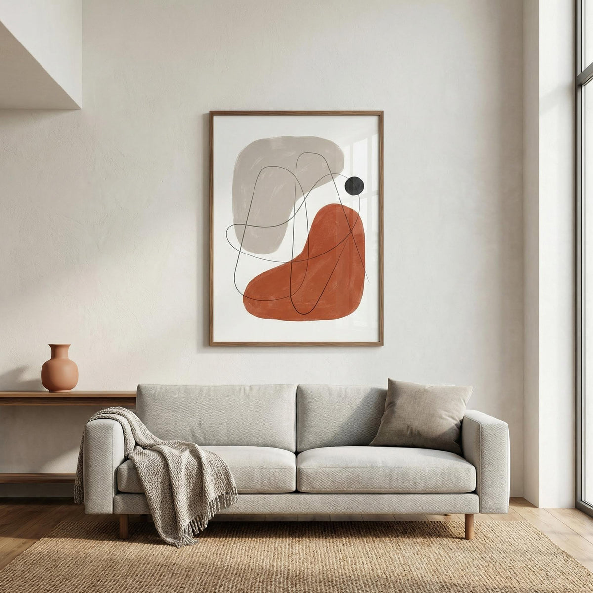 Modern living room with a light gray sofa, abstract art on the wall, and a vase on a side table.