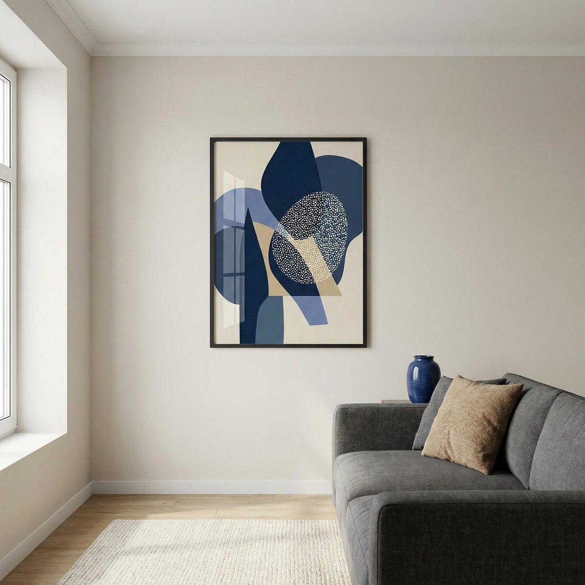 Living room with a gray sofa, abstract art on the wall, and a vase.