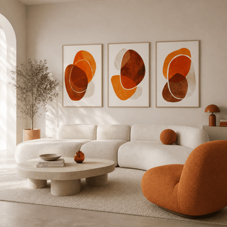 Modern living room with a white sofa, orange chair, and abstract art on the wall.