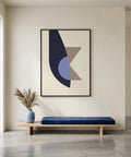 Modern interior with a abstract art piece on the wall, a blue bench, and a vase with dried plants.