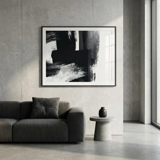 Modern living room with abstract black and white artwork on the wall, gray sofa, and small round table.