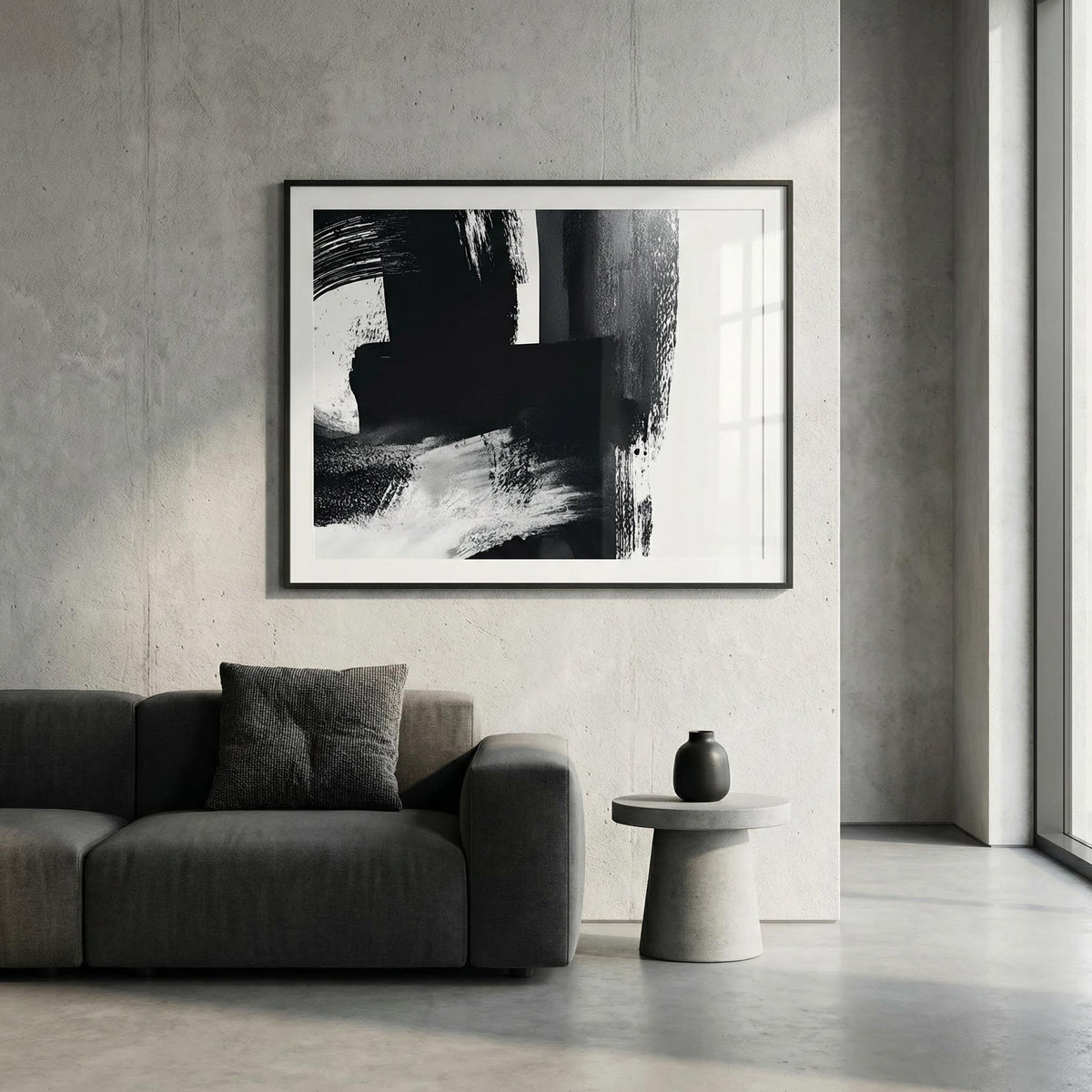 Modern living room with abstract black and white artwork on the wall, gray sofa, and small round table.