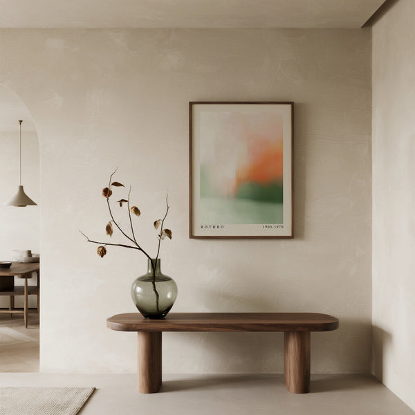 Minimalist interior with a wooden bench, vase with branches, and abstract art on the wall.