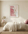 Neatly made bed in a bedroom with a pink abstract painting on the wall.