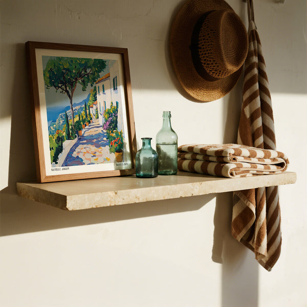 Wooden shelf with a Matisse framed painting, bottles, and folded towels against a white wall.