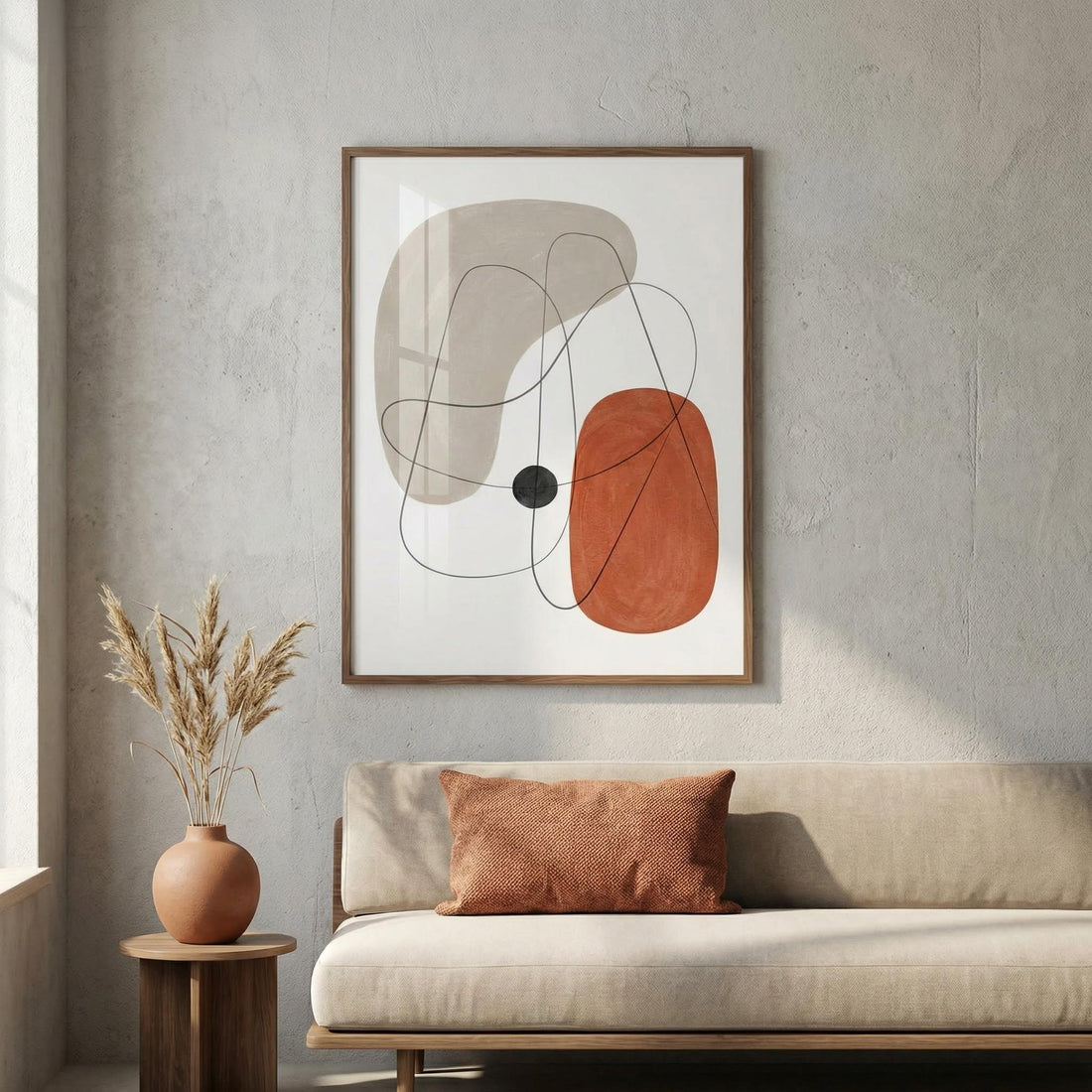 Abstract print of rust and beige organic shapes above a cream sofa with a terracotta cushion
