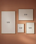 Four framed artworks of different sizes on a peach wall