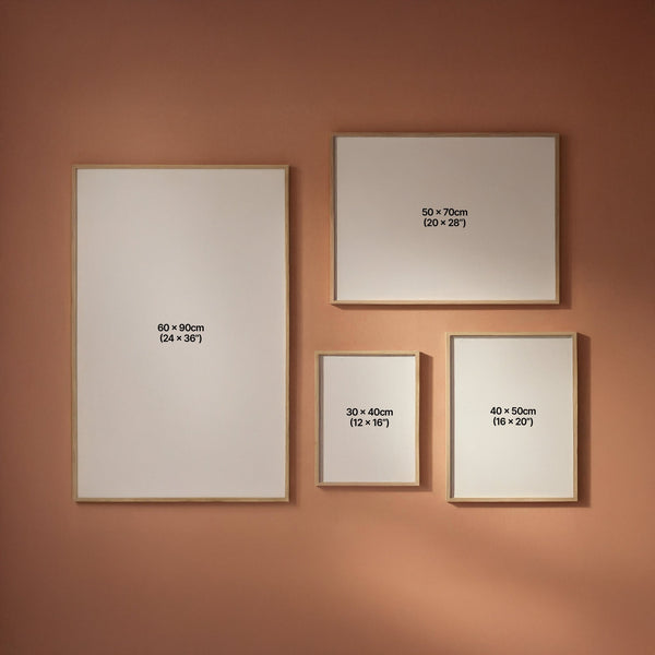 Four framed artworks of different sizes on a peach wall