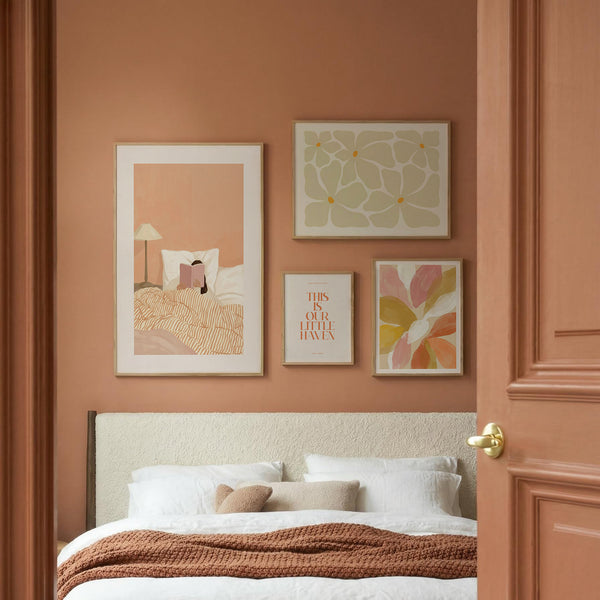 Multicolored flower print set of 4 arranged above a bedroom with peach wall.