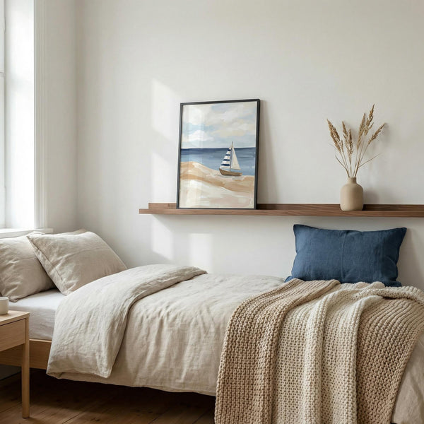 Cozy bedroom with a bed, shelf with decor, and wall art of a small sailboat