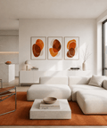 Modern living room with a white sectional sofa, abstract art, and a kitchen in the background.