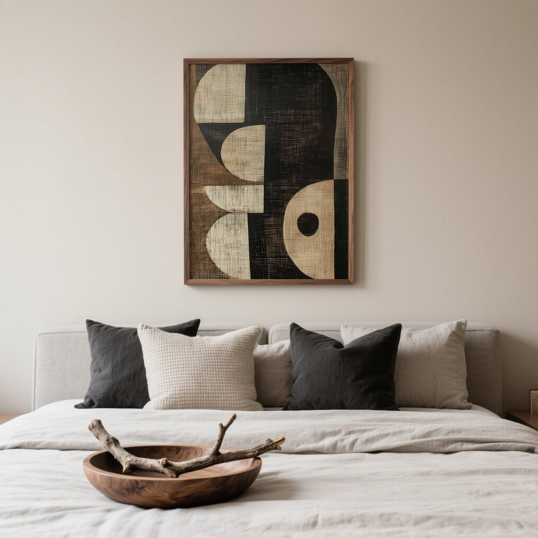 Beige bedroom with linen bedding, black and cream cushions and an abstract print in black, sand and cream above the bed