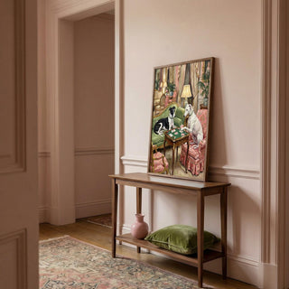 Decorative painting of dogs at a table on a wooden console table in a room with pink walls and a rug.