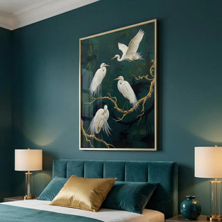 Framed artwork of white birds on a branch above a bed with teal headboard and gold lamps.