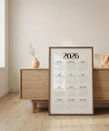 Calendar for 2026 displayed in a minimalistic room with wooden furniture and a vase.