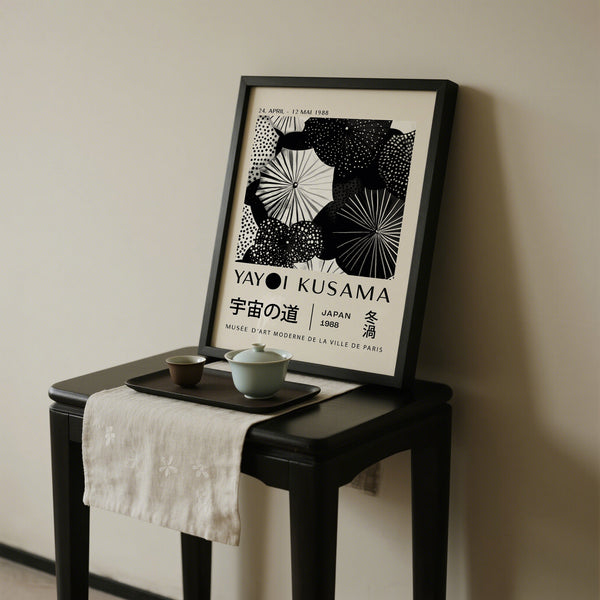 Framed Yayoi Kusama artwork on a small table with tea set