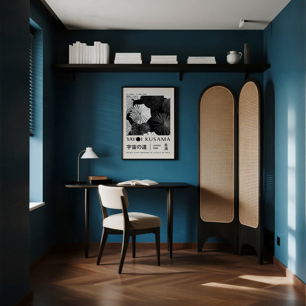 Modern interior with blue walls, a desk, chair, and a Winter Wall art of Yayoi Kusama.