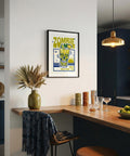 Modern kitchen with a framed poster on the wall, wooden counter, and decorative items.