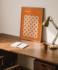 Modern geometric orange poster featuring repeating petal shapes in a square grid.
