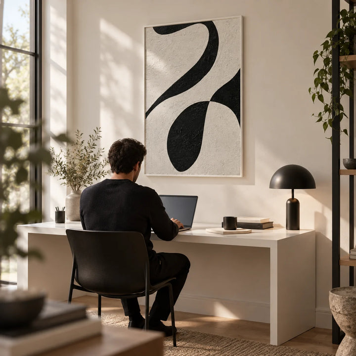 Abstract Black and White Art, framed on the wall of a minimalist home office with a warm white wall