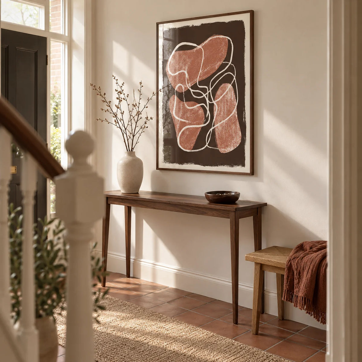 Abstract Earth Tone Print, framed on the wall of a welcoming hallway in a renovated UK terrace with warm white walls and a plain terracotta tiled floor