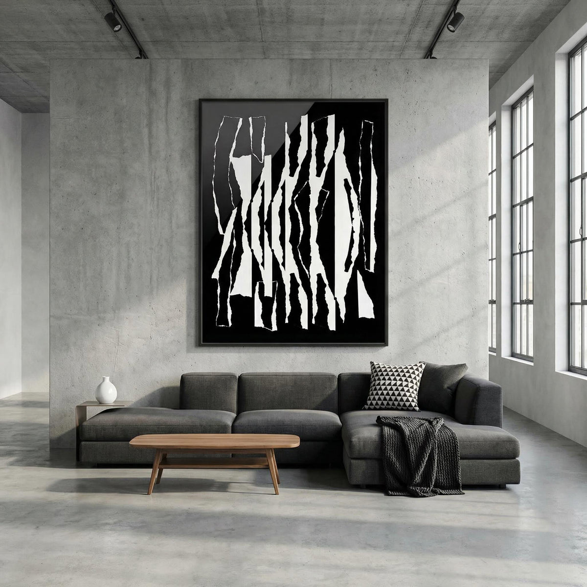 Modern living room with a gray sofa, wooden coffee table, and abstract black and white artwork on the wall.