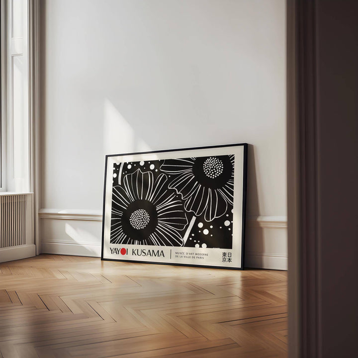 Print leaning on a floor in a minimalist room with black and white flower line-art and wooden floor