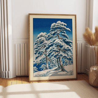 Blue-and-white winter landscape wall art showing snow-laden pines under a clear sky