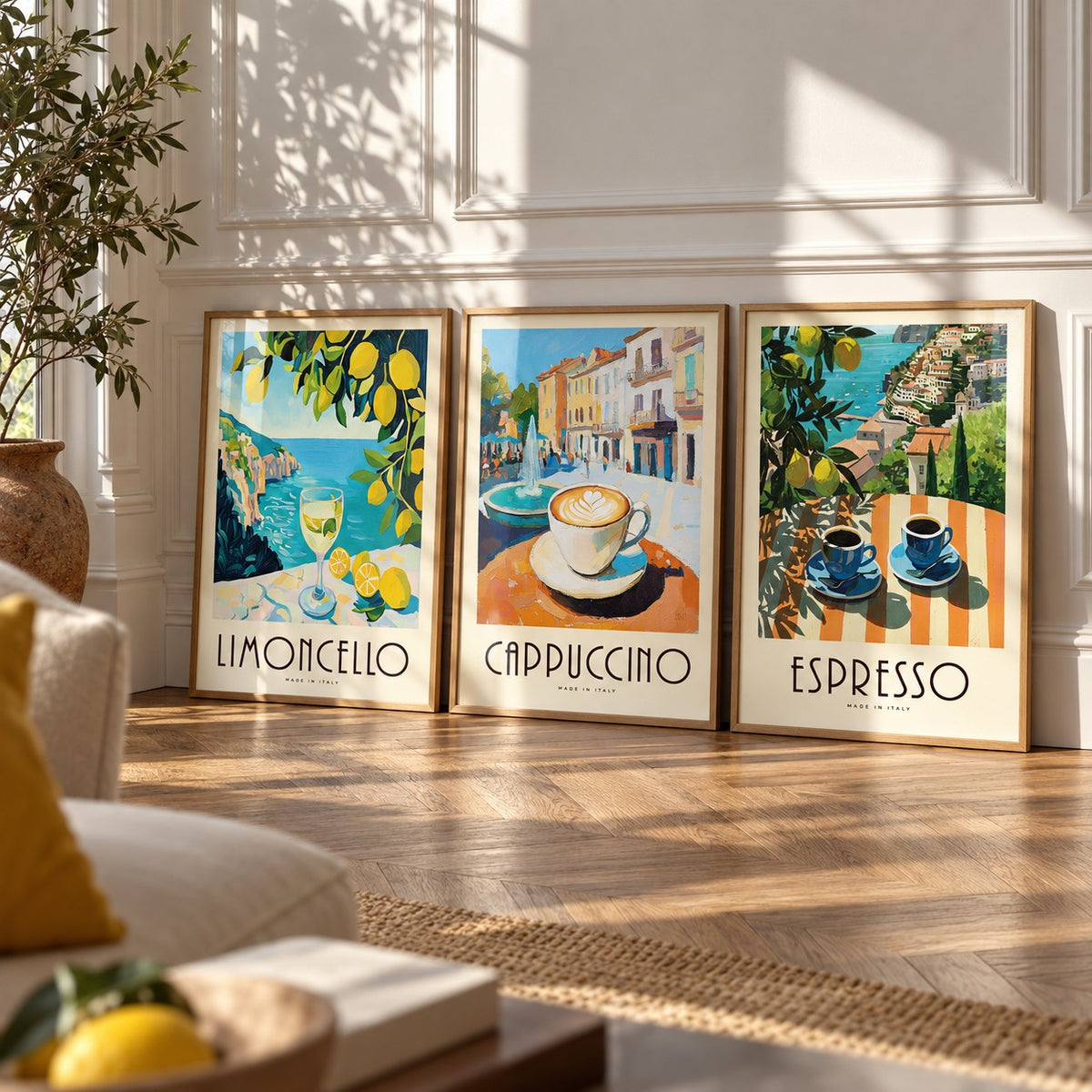 Amalfi Coast Prints Set of 3 styled leaning against a white panelled wall on herringbone parquet: Amalfi Limoncello, Morning Piazza and Amalfi Espresso shown framed side by side (frames not included)