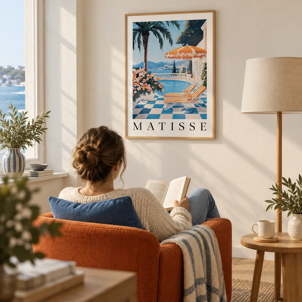 Amalfi Coast Wall Art Print, framed on the wall of a relaxed reading corner in a UK seaside flat with a warm white wall and a pale oak floor in a living room