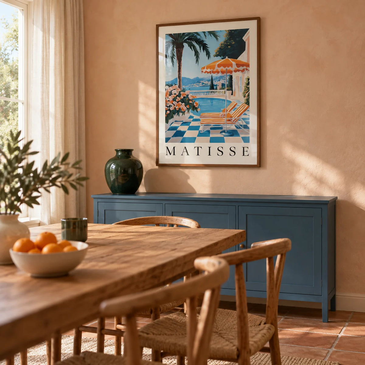 Amalfi Coast Wall Art Print, framed on the wall of a warm Mediterranean-inspired dining room in a UK family home with pale peach plaster walls and a terracotta floor