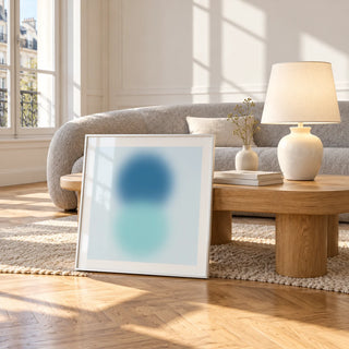 Aqua Print, framed and leaning against a coffee table in a bright living room