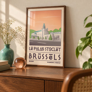 Art Deco Brussels Print, a small A4 framed print leaning on a walnut shelf in a living room