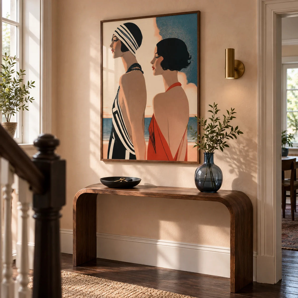 Art Deco Riviera Fashion Print, framed on the wall of a welcoming hallway in a renovated British terrace with pale peach plaster walls and dark timber floorboards