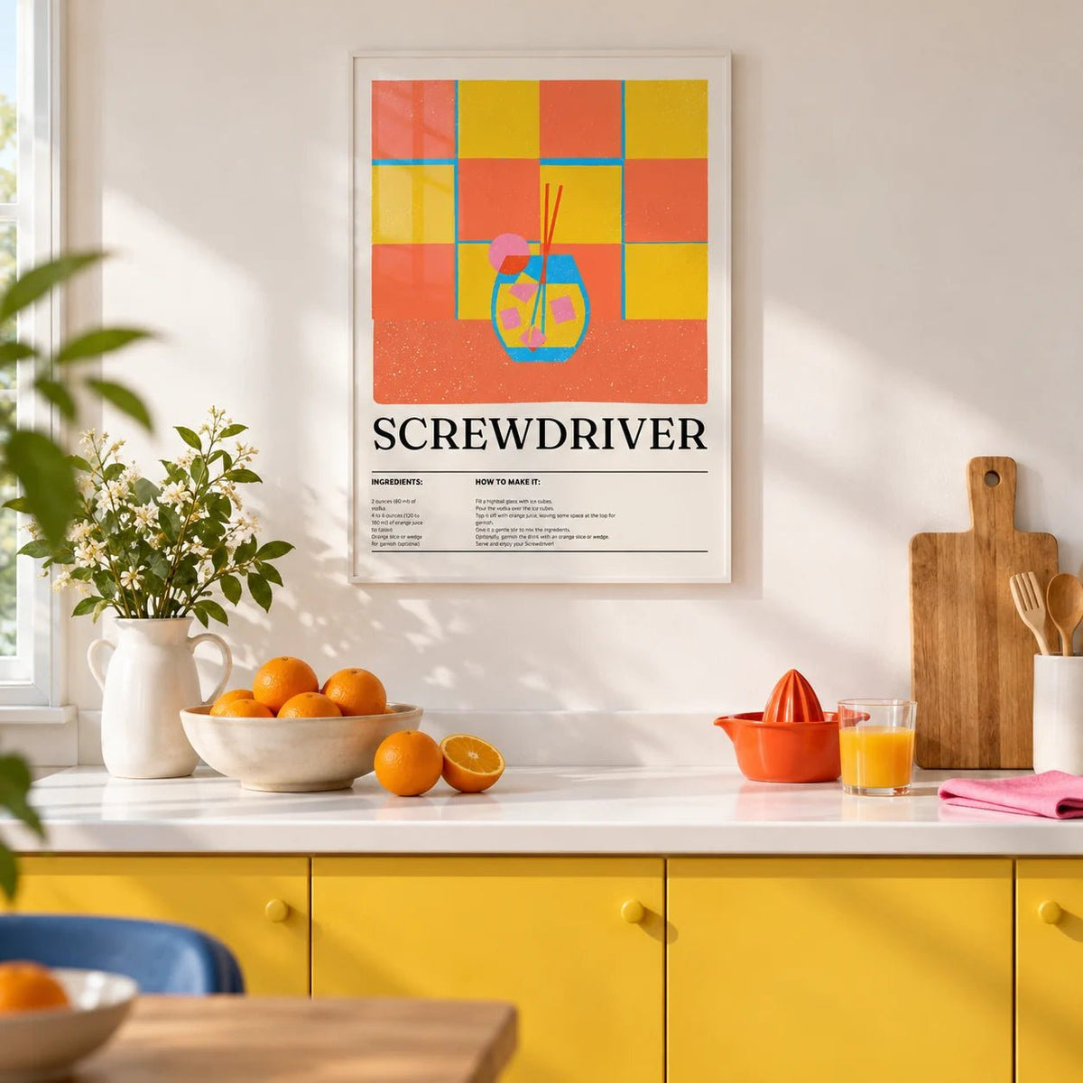 Art Prints Kitchen, framed on the wall of a bright kitchen with plain sunny yellow cabinets and a white worktop