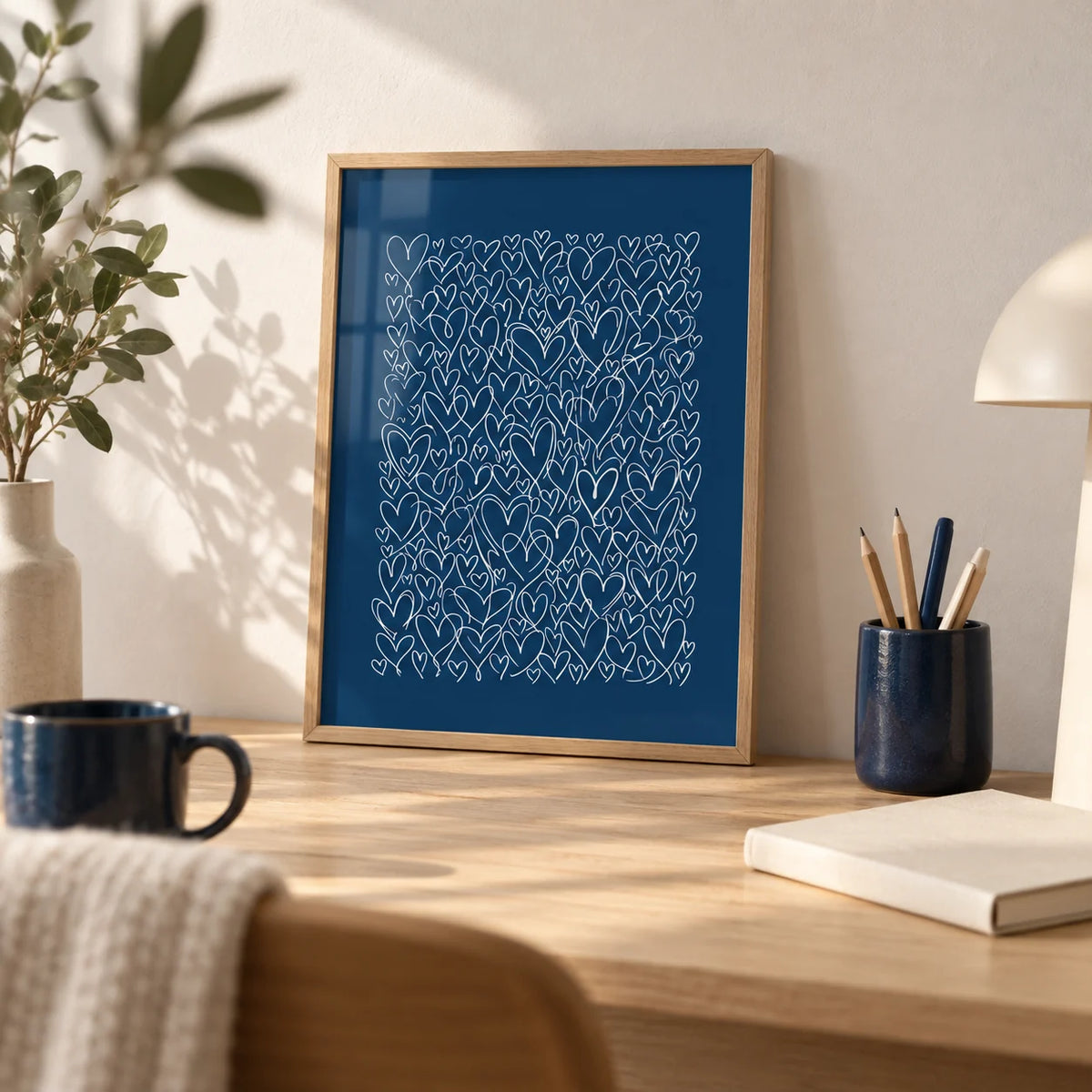 Art with Hearts, a small A4 framed print leaning on a pale oak desk